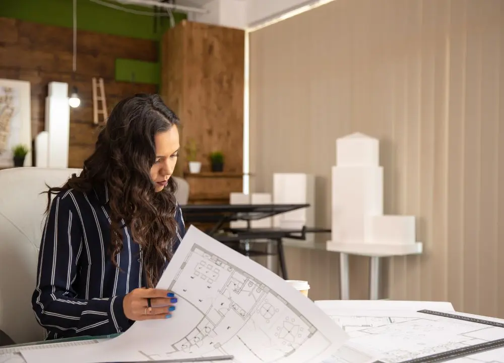 arquiteta-jovem-que-controla-os-esbocos-projeto-imobiliario-local-de-trabalho-aconchegante