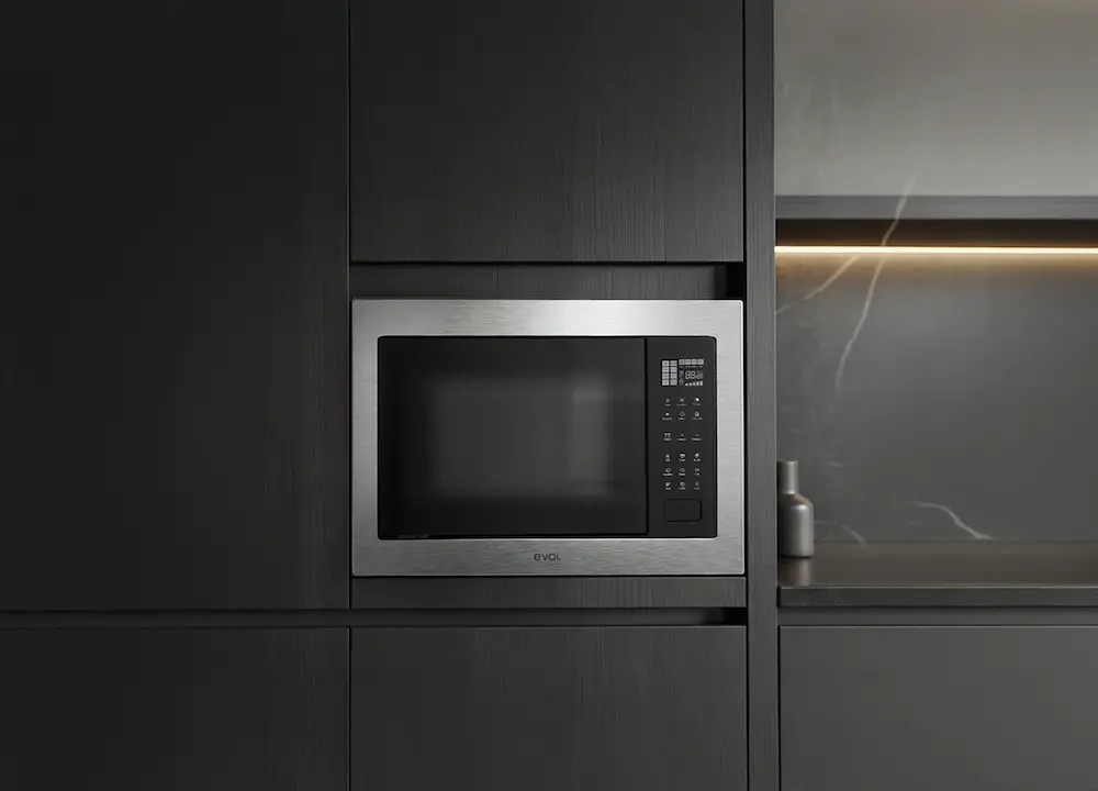 Micro-ondas de embutir em inox integrado à marcenaria escura de cozinha planejada contemporânea, com acabamento minimalista e iluminação indireta ao fundo.
