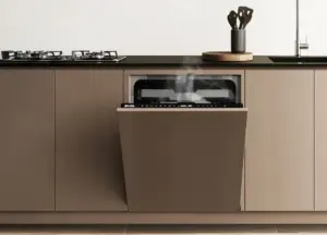 Lava-louças embutida na marcenaria com porta aberta liberando vapor, integrada a cozinha planejada com cooktop e bancada moderna.