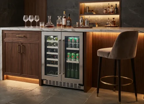 Adega e cervejeira 2 em 1 integrada à marcenaria de um bar gourmet sofisticado, com compartimentos independentes para vinhos e cervejas, portas de vidro, iluminação interna e armazenamento organizado de bebidas prontas para servir.