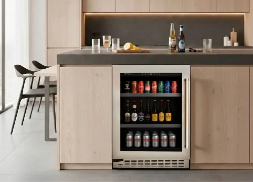 Cervejeira embutida Evol integrada à marcenaria de cozinha planejada, com porta de vidro, acabamento em aço inox e bebidas organizadas em prateleiras internas sob bancada moderna.